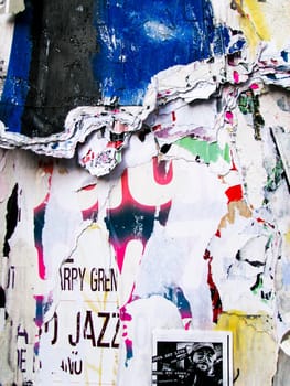 Torn up posters and garbage on a wall
