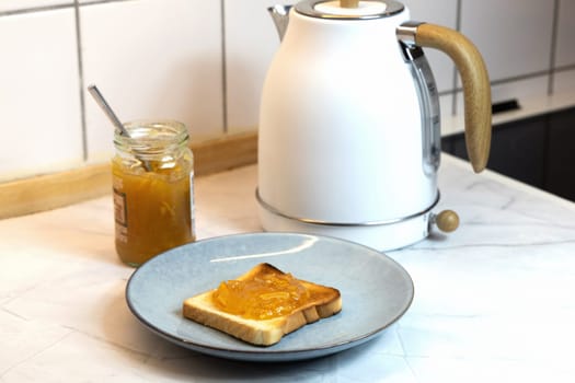 Breakfast served on the kitchen table with fresh toast bread and jam. High quality photo