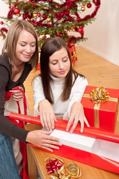 Two women packing Christmas present