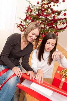 Two women packing Christmas present