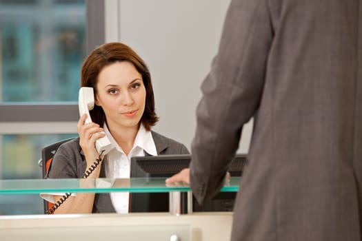 Young caucassian secretary assisting businessman
