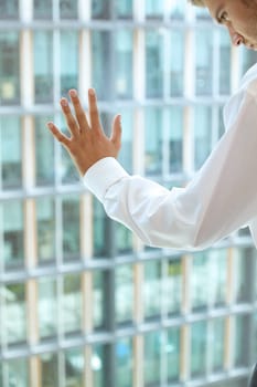 Young caucassian businessman standing against office window