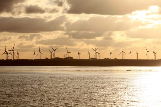 Wind turbines at sunrise by the sea