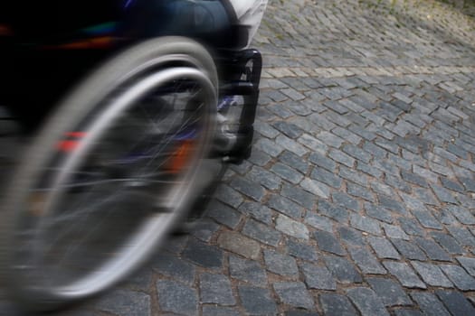 speed - detail wheelchair on cobblestones