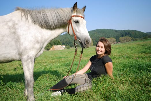 Young woman with riding pony