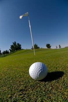 Golf ball on green with flag