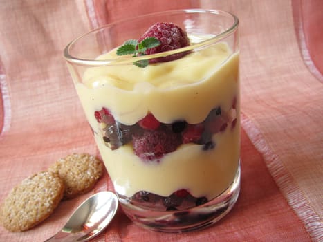 Vanilla pudding with wild berries in a glass
