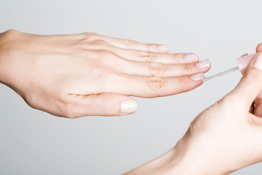 Young woman doing manicure