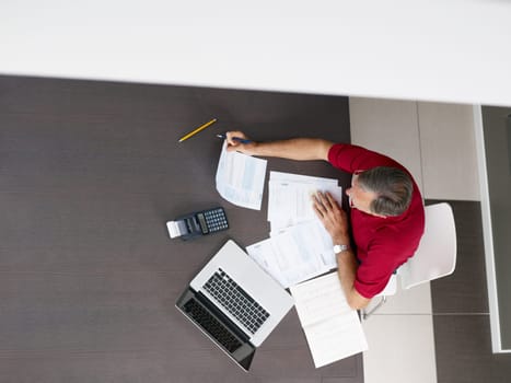 Senior man checking home finances. High angle view, copy space