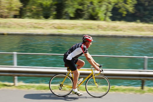 Senior bicyclist on road bike. Blurred background. Copy space