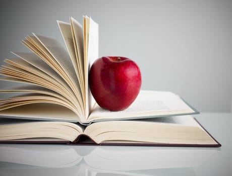 pile of books and red apple on desk. Copy space