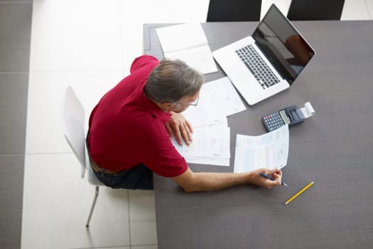 Senior man checking home finances. High angle view
