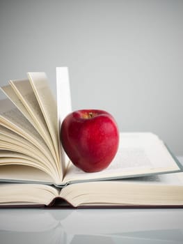 pile of books and red apple on desk. Copy space