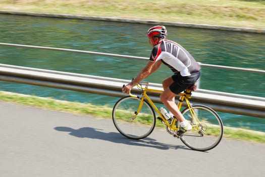 Senior bicyclist on road bike. Blurred background. Copy space