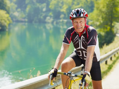 senior man on road bike, looking at camera. Copy space
