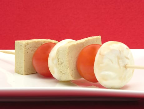 Vegetable skewer with tofu and rice on white plate