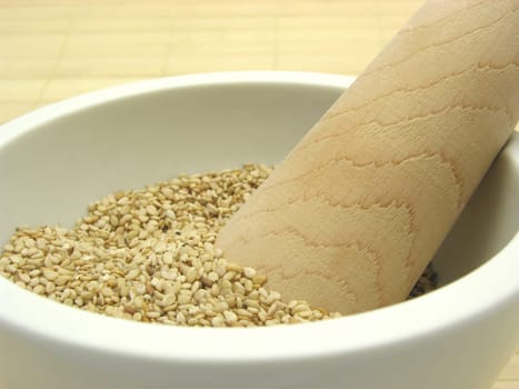 Sesame seeds in porcelain bowl with mortar
