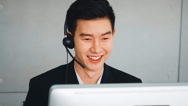 Business people wearing headset working in office to support remote customer or colleague. Call center, telemarketing, customer support agent provide service on telephone video conference call. Jivy