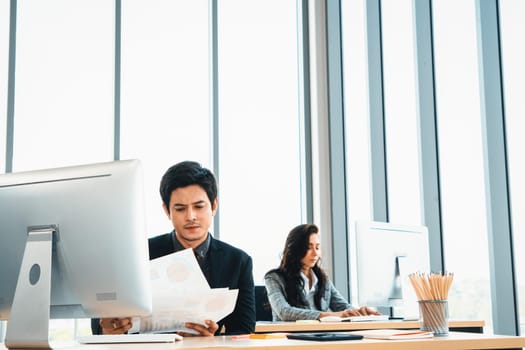 Business people working at table in modern office room while analyzing financial data report . Jivy