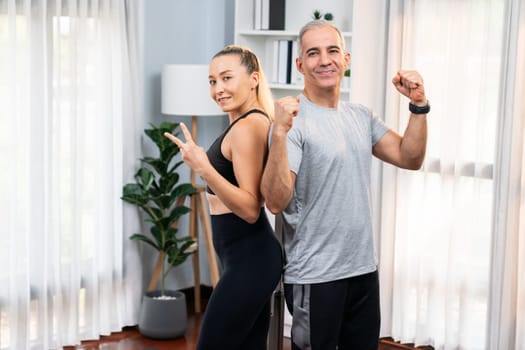 Athletic and sporty senior couple portrait in sportswear with successful or celebrating after overcome struggle posture as home exercise concept with healthy fit body lifestyle after retirement. Clout