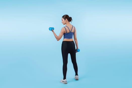 Vigorous energetic woman doing dumbbell weight lifting exercise on isolated background. Young athletic asian woman strength and endurance training session as body workout routine.