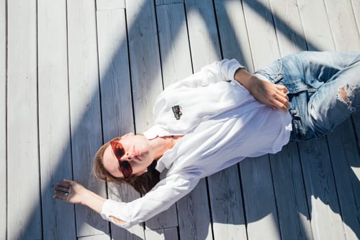 woman lies on a wooden floor on the street