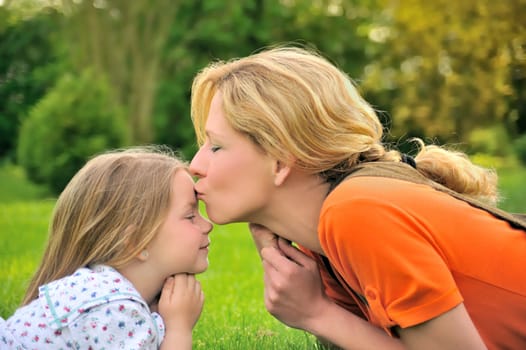 Mother is kissing her daughter