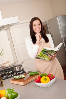 Young smiling woman with groceries in the kitchen