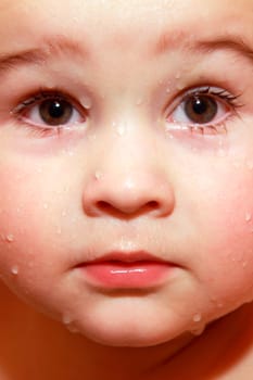 Close-up face baby with drops in bathroom