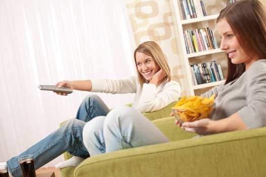 Two female teenager watching television
