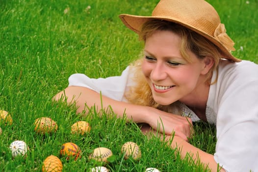 Young woman and easter eggs on grass - Easter time