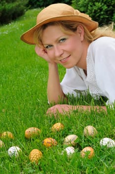 Young woman and easter eggs on grass - Easter time