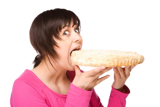 Young woman bites into a cake