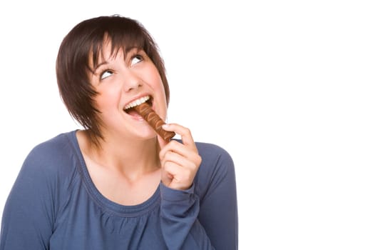 Young woman snacking on a chocolate bar.