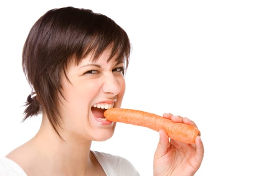 Young woman bites into a carrot