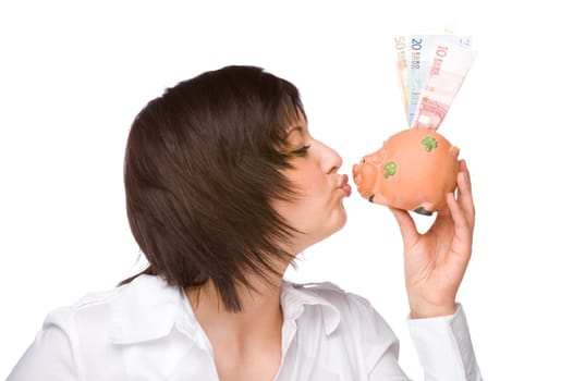 Young woman kissing a piggy bank