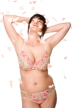 Young woman with flying rose petals