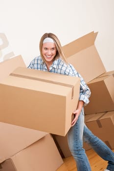 Moving house Woman unpacking box with kitchen dishes