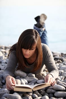Woman with holiday reading by the sea
