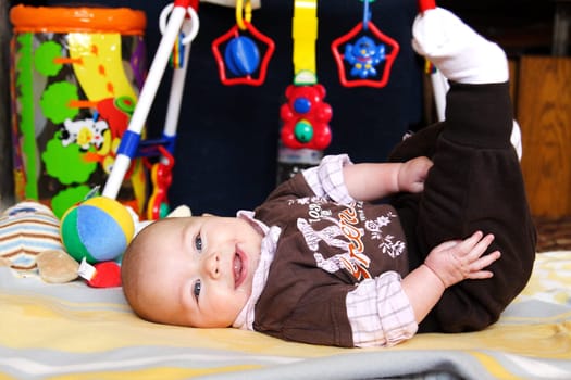 Baby lying on his back on play mat