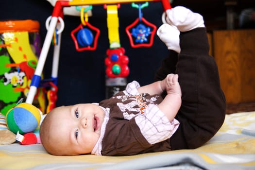 Baby lying on his back on play mat