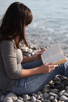 Woman with holiday reading by the sea 2