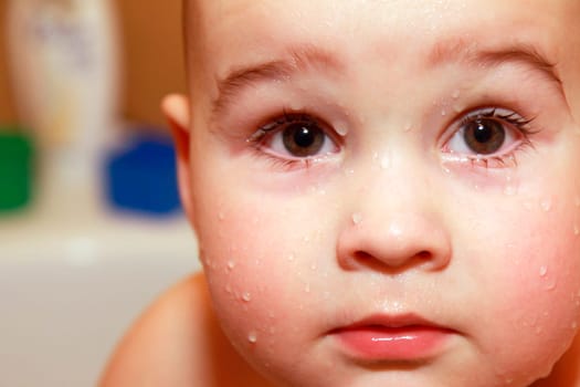 Close-up face baby with drops in bathroom