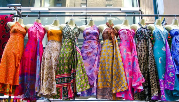 Several dresses hanging up at a market