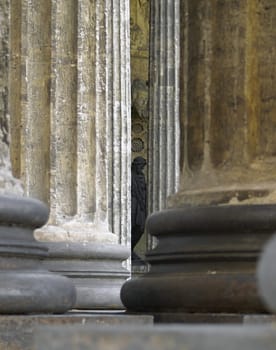 Columns of Ancient Temple and Sculpture of a Saint in Background