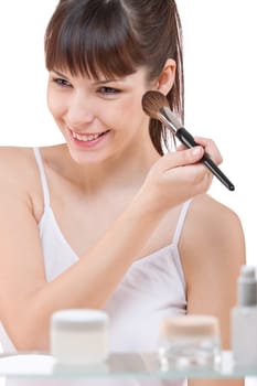 Body care Young woman applying powder with brush