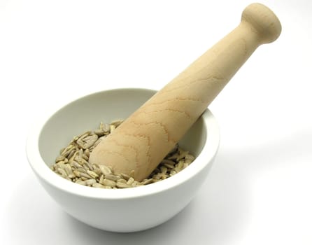 Sunflower seeds in porcelain bowl with mortar