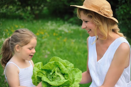 Young mother and daughter with lettuce