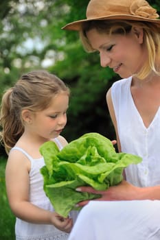 Young mother and daughter with lettuce