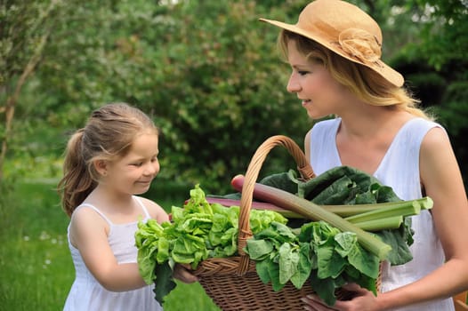 Young woman and daughter with fresh vegetable